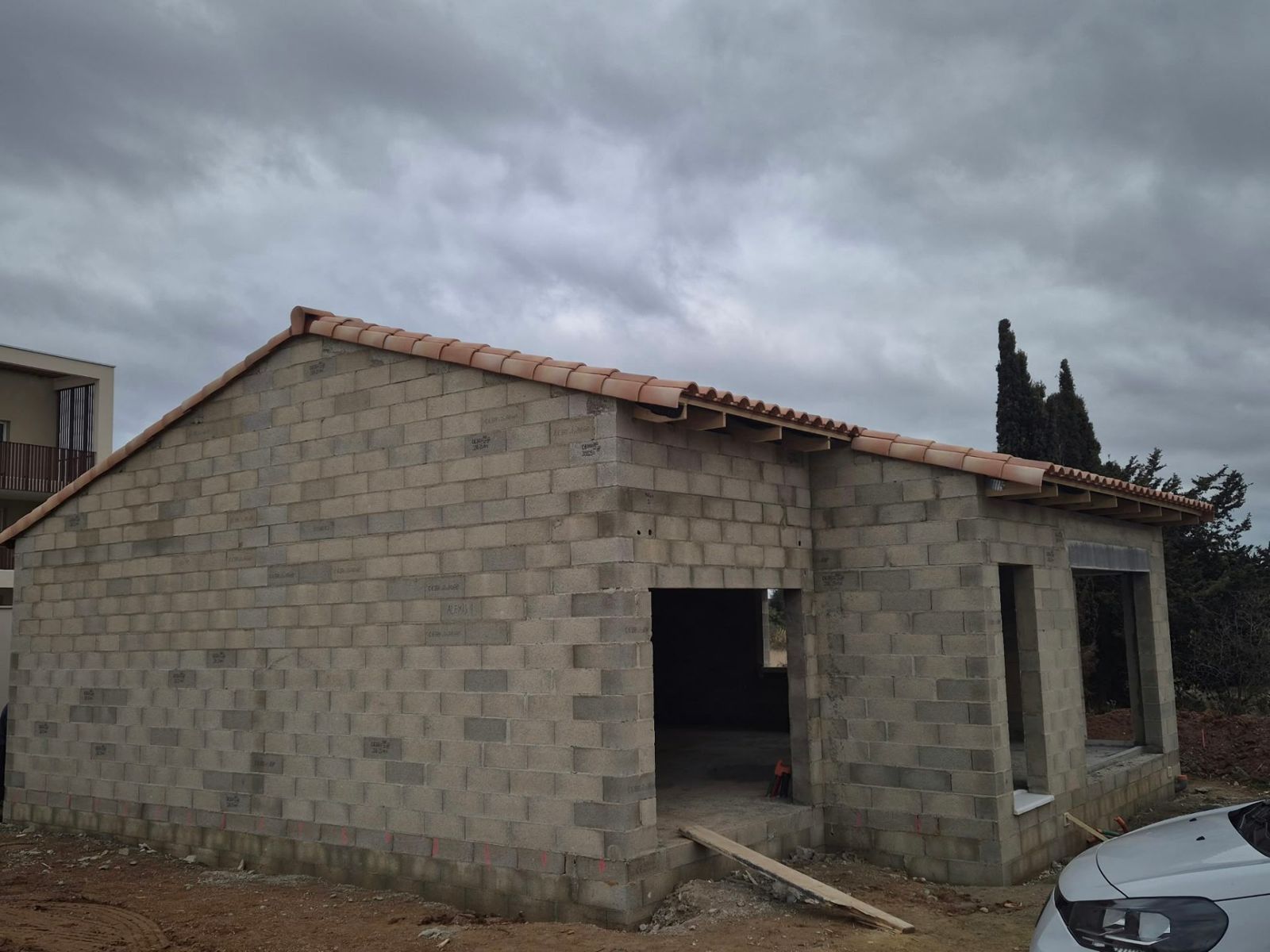 Maison en blocs béton avec charpente et tuiles posées