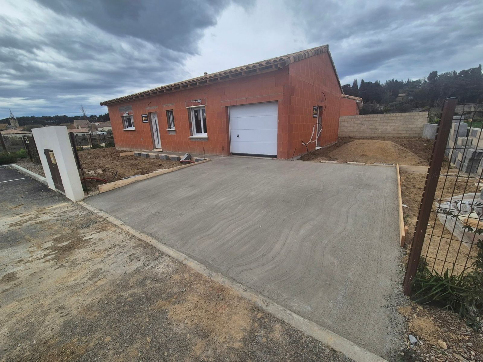 Allée béton menant à une maison en briques