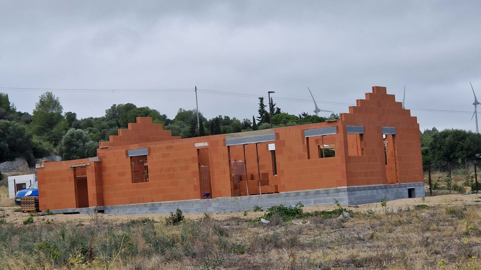 Maison en briques en cours d'élévation sur terrain naturel