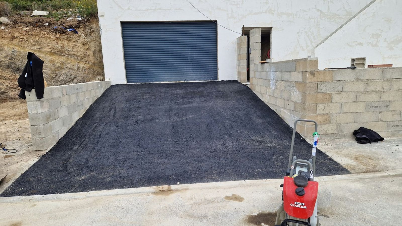 Rampe d'accès au garage avec murs en blocs béton
